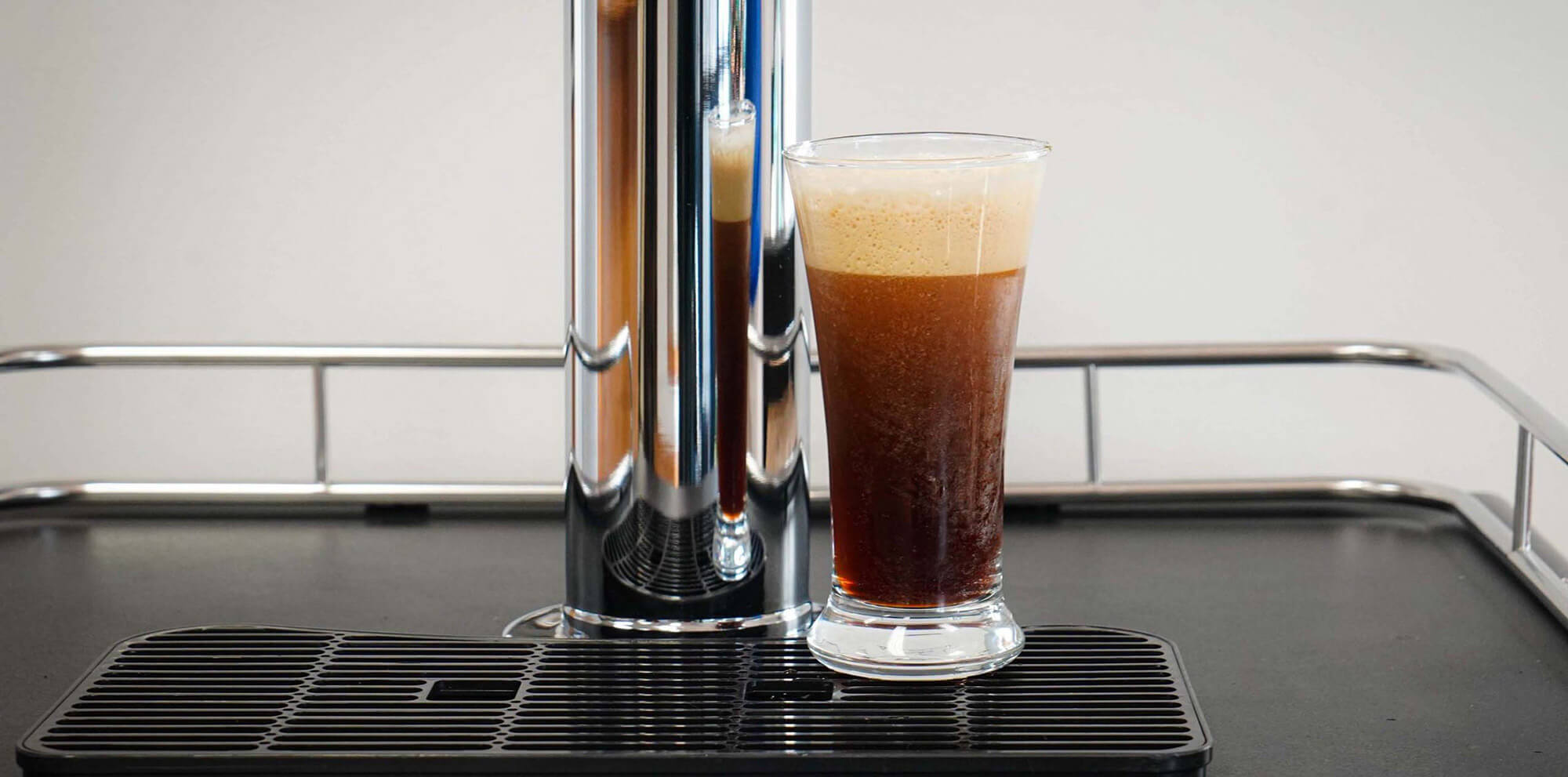 A glass of cold brew coffee sitting on a kegerator