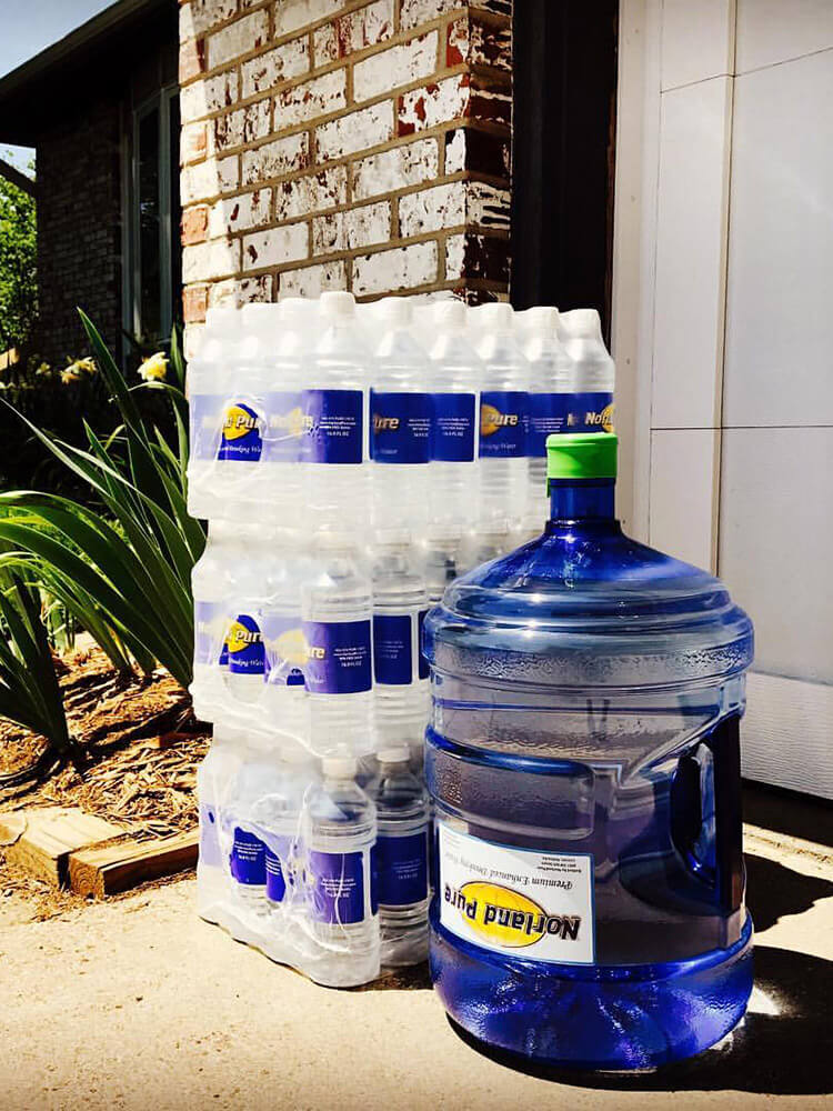 A residential delivery of Norland Pure water bottles and a 5-gallon water jug