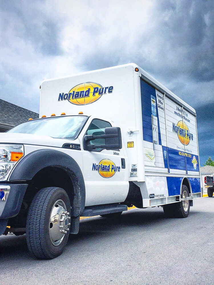 A Norland Pure water delivery truck in front of storm clouds